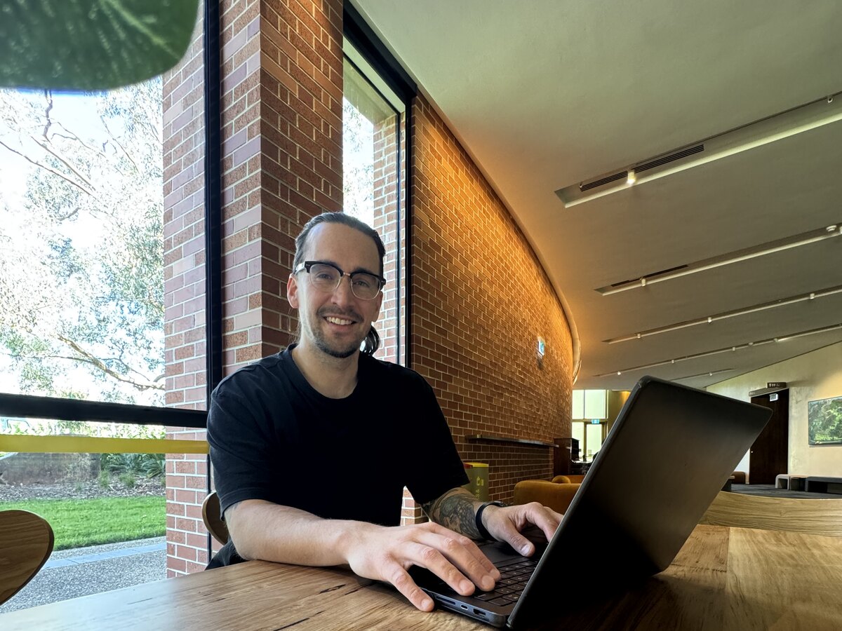 Tim McCartney, founder of Scalus, smiling at his laptop on the morning the acceptance email from Anthropic arrived