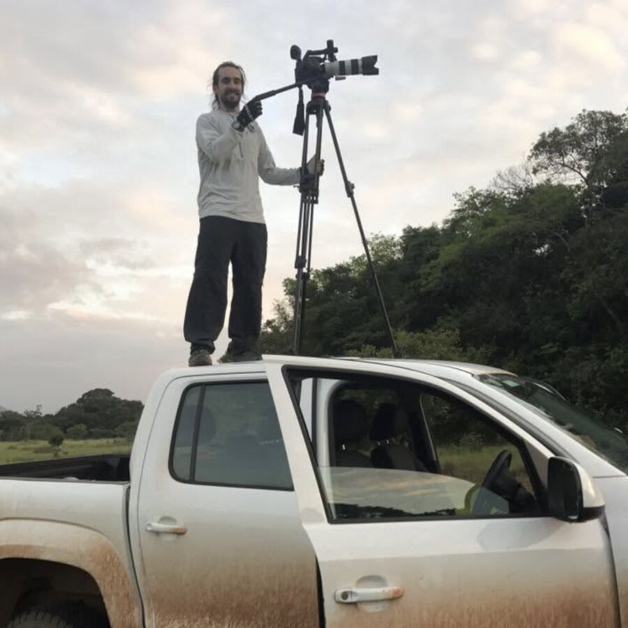 Tim McCartney filming from the roof of a ute with a tripod and long lens